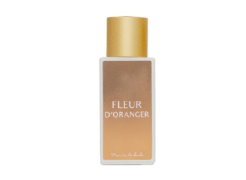Frasco de perfume blanco con etiqueta dorada y tapón dorado Toni Cabal Fleur dÓranger